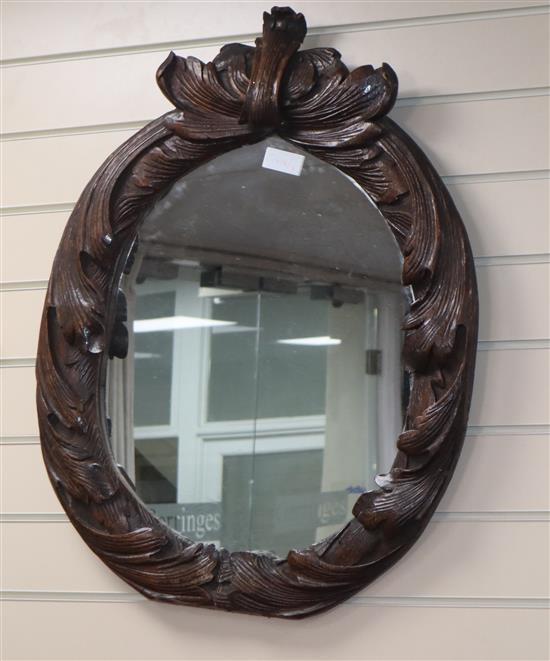 An early 19th century oval carved wall mirror
